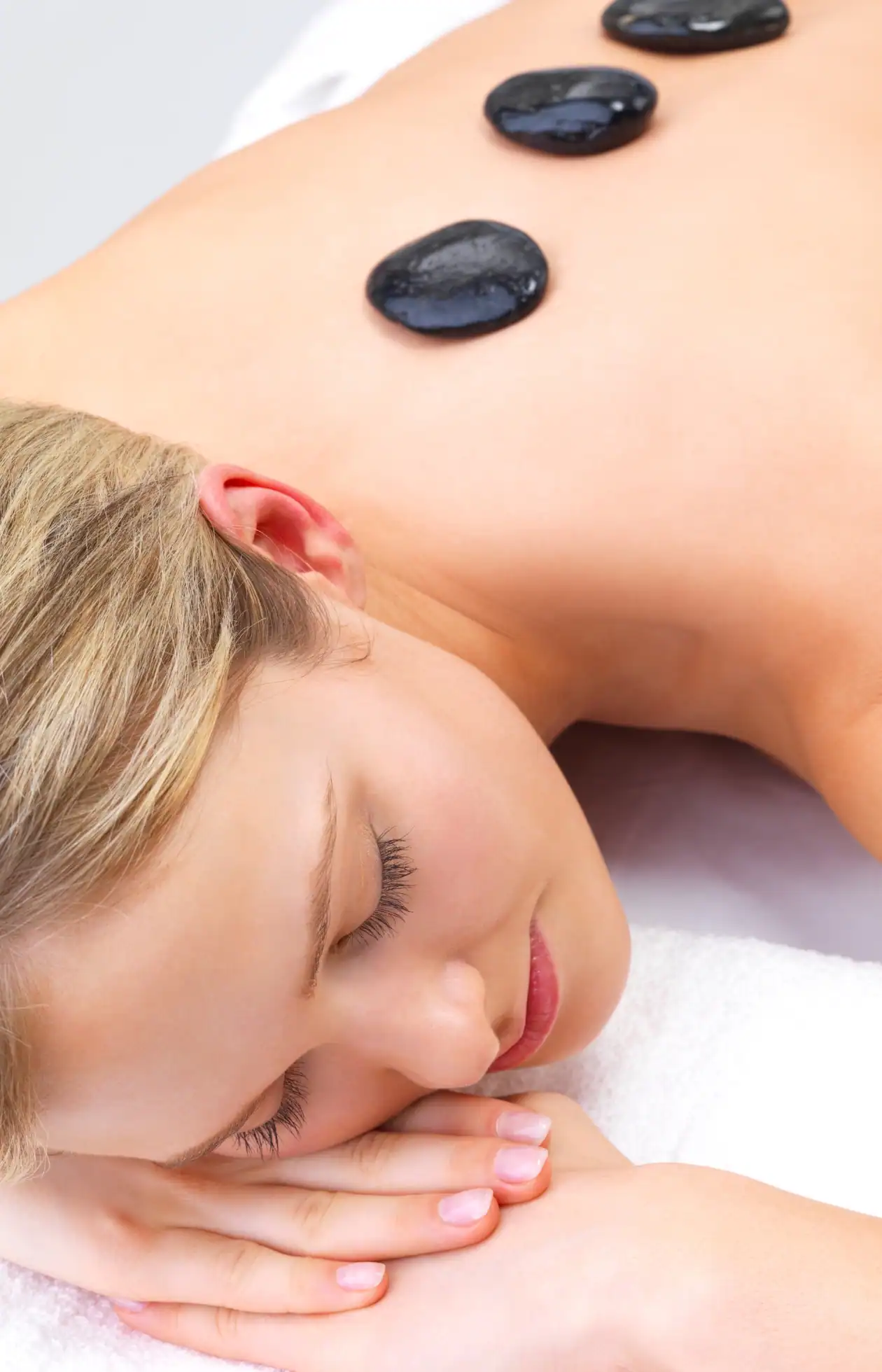 Gym member receiving a hot stone massage at Alpine Fitness Recovery Spa, showcasing massage therapy for muscle recovery, stress relief, pain reduction, and post-workout recovery; recovery spa services including hot stone massage, therapeutic bodywork, red light therapy, sauna, steam room, cold plunge, and wellness recovery treatments. Contact us today for help with recovery spa near me, recovery spa services, athletic recovery spa, fitness recovery center, wellness recovery spa near me, post-workout recovery services, muscle recovery therapy near me, sports recovery treatments, red light therapy near me, red light therapy for muscle recovery, red light therapy for inflammation and pain relief, infrared light therapy near me, sauna near me, infrared sauna therapy, sauna for detox and recovery, sauna after workout benefits, steam room near me, steam room therapy benefits, steam room for relaxation and circulation, steam room recovery therapy, cold plunge near me, cold plunge therapy benefits, ice bath recovery near me, contrast therapy sauna and cold plunge, hydrotherapy recovery services, massage therapy near me, therapeutic massage near me, deep tissue massage recovery, sports massage therapy near me, hot stone massage therapy near me, recovery spa Alpine UT, recovery spa Lehi UT, recovery spa American Fork UT, recovery spa Highland UT, gym with recovery spa near me, holistic recovery services, injury prevention recovery therapy, stress relief spa treatments near me, performance recovery services, wellness spa for athletes near me.